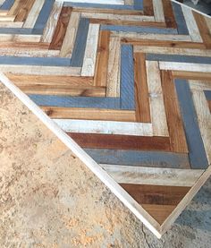 a wooden table top made out of different colored wood planks and plywood boards