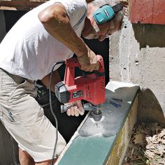 a man using a power tool to cut concrete