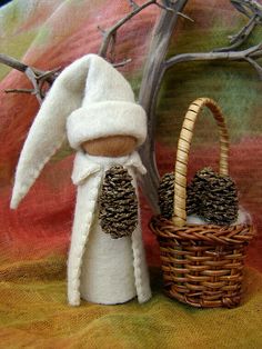 a small stuffed animal next to a basket with pine cones