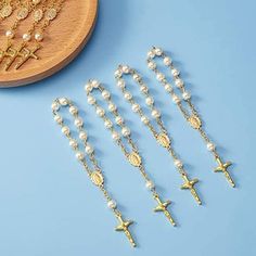 six rosarys and a wooden cross on a blue background