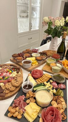 an assortment of cheeses, meats and crackers on a table