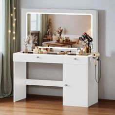 a white vanity table with a mirror and lights