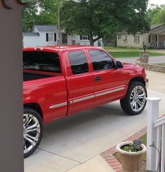 a red pick up truck parked in front of a house