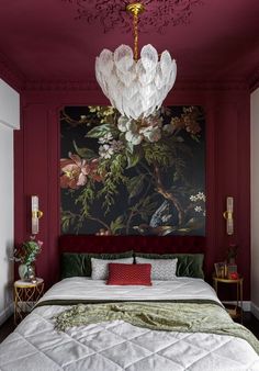 a bedroom with red walls and a large painting on the wall above the headboard