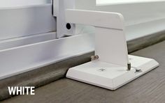 an electronic device is sitting on the ground next to a window sill with white trim