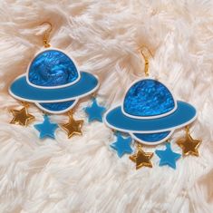 *These out of this world Saturn earrings are made with so many fun and interesting details. *They were laser cut with white, detailed blue, teal, and gold acrylic. *Three star charms are attached under each Saturn piece. *The pieces were then added to hypoallergenic gold tone earring hooks. **These earrings can be made with sterling silver hooks, regular posts, or wrap around hooks -- if you prefer any of these options just let us know in the notes to seller section during checkout! CONTACT: *Fe Whimsical Blue Nickel-free Earrings, Novelty Blue Drop Earrings, Blue Handmade Novelty Earrings, Handmade Blue Novelty Earrings, Fun Blue Nickel-free Earrings, Themed Blue Earrings For Gifts, Blue Themed Earrings For Gift, Themed Blue Earrings For Gift, Blue Fun Dangle Jewelry