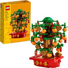 a lego tree with lots of pumpkins on it next to a box and package