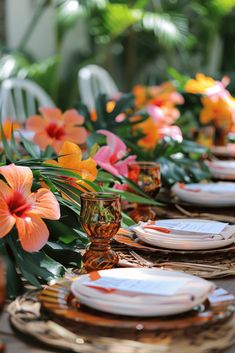 the table is set with orange and pink flowers