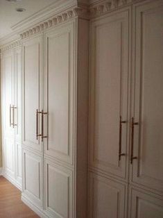 an empty room with white closets and wood flooring on the walls, along with a large window