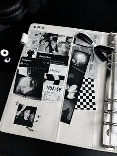 a black and white photo album on a desk with headphones next to the book