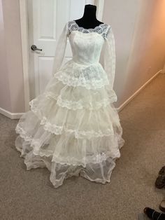 a white wedding dress on display in front of a door