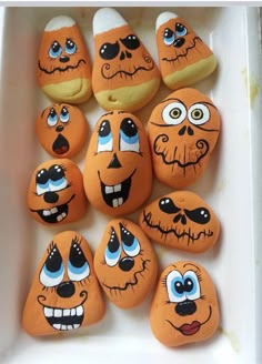 there are many pumpkin faces painted on rocks