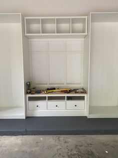 an empty room with built in cabinets and drawers on the wall, including a bench