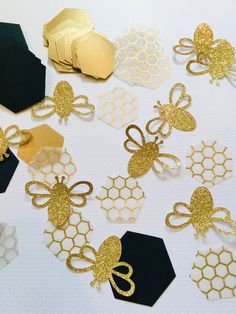 gold and black paper cut outs with honeycombs, bows, and bees on them