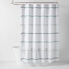 a white shower curtain with green lines on the outside and inside, hanging from a metal rod