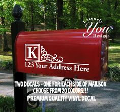 a red mailbox sitting on the side of a road next to some trees and grass