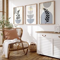 three framed art prints hang on the wall next to a white dresser and wooden chair