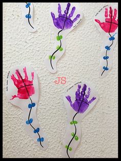 four handprints are displayed on the wall with different colors and shapes in them