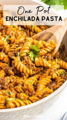 one pot enchilada pasta in a white bowl with a wooden spoon