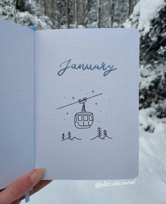 someone holding up a notebook with a drawing of a ski lift