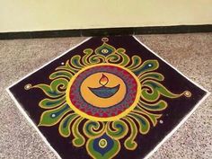 an artistic design on the ground in front of a wall with a lit candle inside