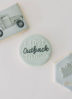 two cookies decorated with the words first outback adventure and an image of a pick - up truck