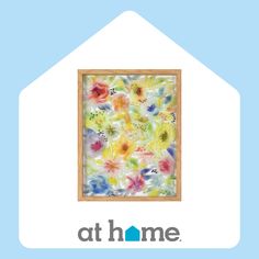 the logo for at home with an image of colorful flowers in a wooden frame on a blue background