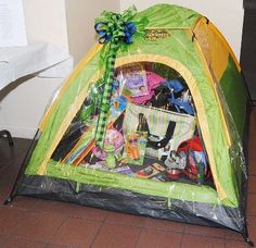 a green and yellow tent sitting on top of a floor next to a white wall