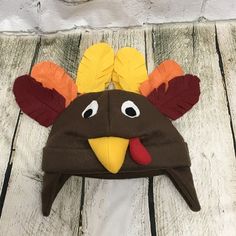 a brown turkey hat with orange and yellow feathers