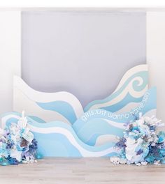 two blue and white bouquets sitting on top of a wooden floor next to a wall