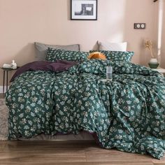 a bedroom with a bed covered in green and purple comforters, pillows and blankets