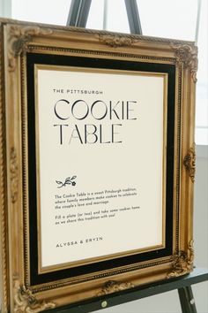 a sign that is on top of a easel in front of a window with the words cookie table written below it