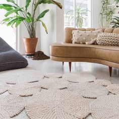 a living room filled with furniture and potted plants on top of a white floor