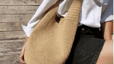 a person wearing a white shirt and brown tie holding a beige bag in their hands