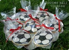 cookies decorated with soccer balls in plastic wrappers on the grass, ready to be eaten