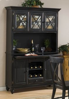 a dining room hutch with wine bottles and glasses