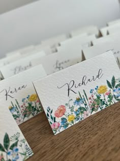 place cards with flowers on them sitting on a table