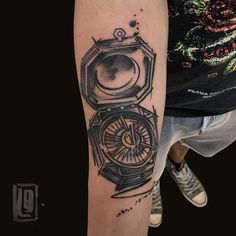 a man with a tattoo on his arm has a compass in the middle of it