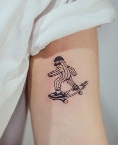 a person with a tattoo on their arm riding a skateboard