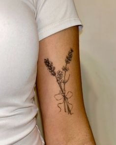 a woman with a tattoo on her arm has a flower in the shape of a heart