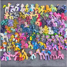 a pile of pony toys sitting on top of a floor