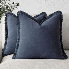 two blue pillows sitting on top of a couch