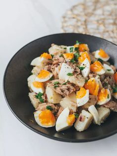 a black bowl filled with food on top of a table