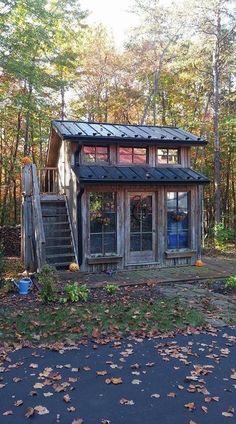 a small wooden house in the woods with stairs leading up to it's roof