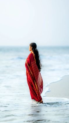 a woman is standing in the water at the beach