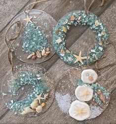 three glass ornaments with seashells and starfish on them