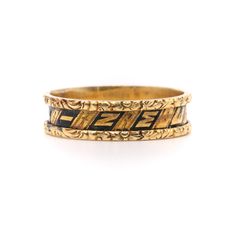 A Victorian black enamel and yellow gold ring, comprising black enamelled panels, reading "In Memory Of”, with engraving and carved floral edges, in 18 karat yellow gold. This meaningful band ring sports beautiful carved edges to the band. These edges are raised, and exquisitely carved with flowers and elegant scrolls. The recessed section of the band is complete with black enamelled panels, with letters in gold, reading "In Memory Of”, in dedication to a lost loved one. These enamelled panels a