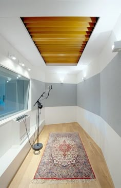 an empty room with a large rug on the floor and a light fixture in the corner