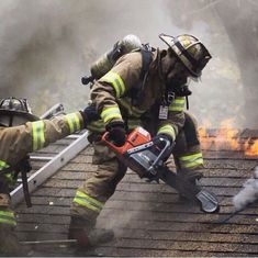 two fire fighters working on the roof of a house