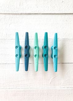 four blue toothbrushes lined up on a white wall